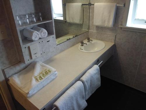 a bathroom with a sink and a counter with towels at The Redwood Hotel in Christchurch