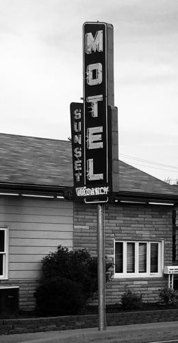 una señal para un motel frente a un edificio en Sunset Motel en Waterloo