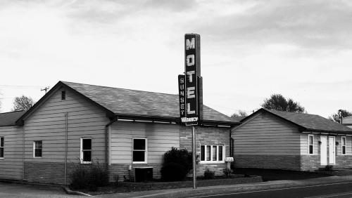 une photo en noir et blanc d'un bâtiment avec un panneau dans l'établissement Sunset Motel, à Waterloo
