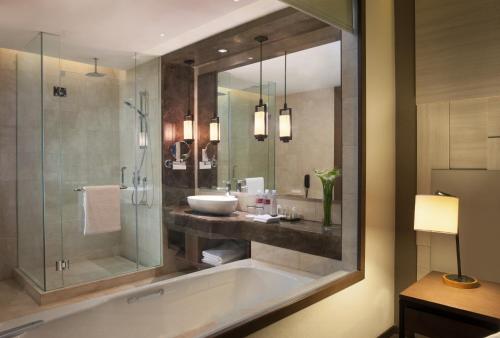 a bathroom with a tub and a sink and a shower at Crowne Plaza Bandung, an IHG Hotel in Bandung