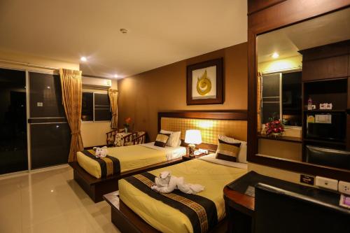 a hotel room with two beds with towels on them at Madina Rayong Hotel in Rayong