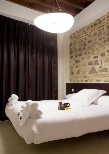 a bedroom with a large bed with towels on it at Antidoto Rooms San Agustín - Recomendado para adultos in Toledo