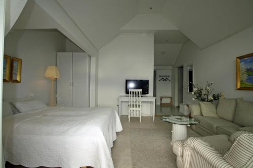 a bedroom with a bed and a couch and a tv at Sunde Fjord Hotel, free and easy parking in Solavagen