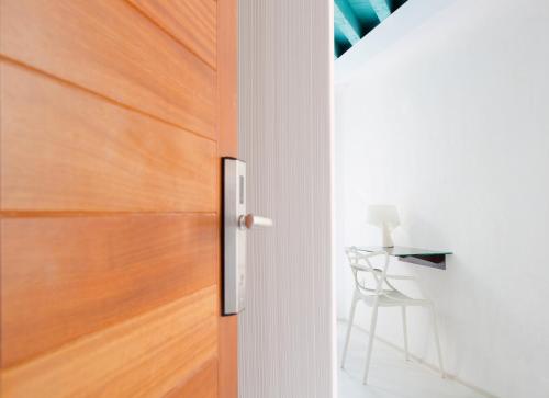 a wooden door with a chair next to a table at Antidoto Rooms San Agustín - Recomendado para adultos in Toledo
