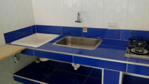 una cocina azul y blanca con fregadero en Apartamento 2D Ed.El Lago, en Santa Marta
