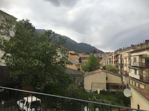 a white van parked in a city with buildings at Hôtel U Passa Tempu in Corte