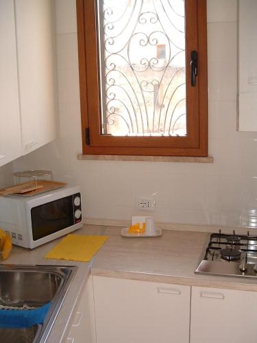 a kitchen counter with a microwave and a window at La Corte di Zaccaria in Mazara del Vallo