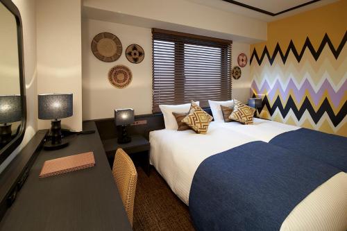 um quarto com uma cama e uma secretária com uma televisão em DEL style Osaka Higashi Temma by Daiwa Roynet Hotel em Osaka