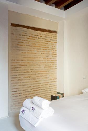 a bedroom with a white bed with towels on it at Antidoto Rooms San Agustín - Recomendado para adultos in Toledo