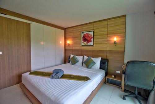 a bedroom with a bed and a chair in it at Pool Access 89 @Rawai Hotel in Rawai Beach
