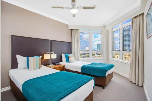 a hotel room with two beds and two windows at BreakFree Moroccan in Gold Coast