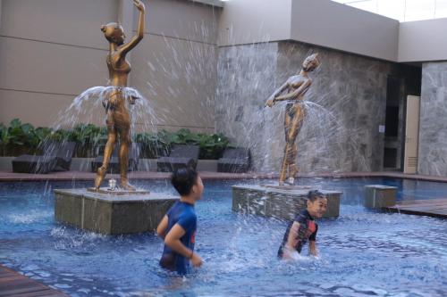 two young boys playing in a fountain in a building at Aston Banyuwangi Hotel and Conference Center in Banyuwangi