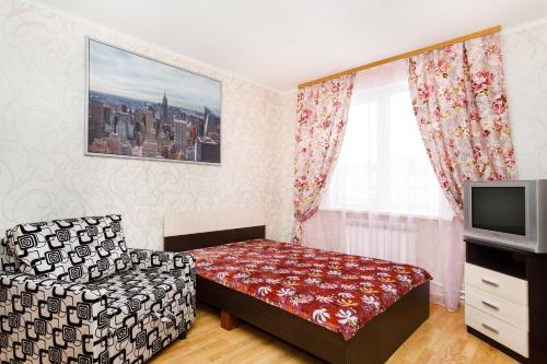 エカテリンブルクにあるКвартира в центре на Хохрякова 100のベッド1台とテレビが備わる小さな客室です。