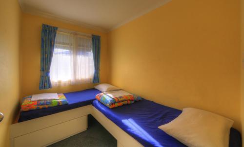 two beds in a small room with a window at Beachcomber Holiday Park in Potato Point