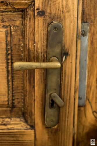 an old wooden door with a metal door handle at Liget Vendégház in Révfülöp