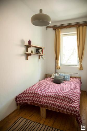 a bed sitting in a room with a window at Liget Vendégház in Révfülöp