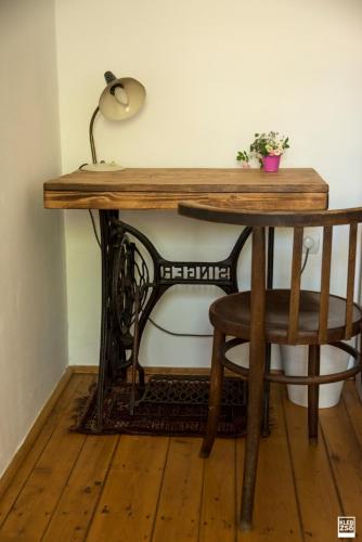 a wooden table with a lamp and a chair at Liget Vendégház in Révfülöp
