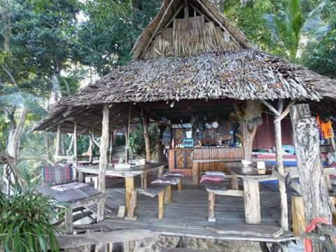 un pabellón con mesas y sillas y techo de paja en Nice View Bungalow en Koh Chang