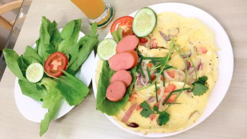 a plate of food with meat and vegetables on a table at Ailen Garden 2 Hotel in Ho Chi Minh City