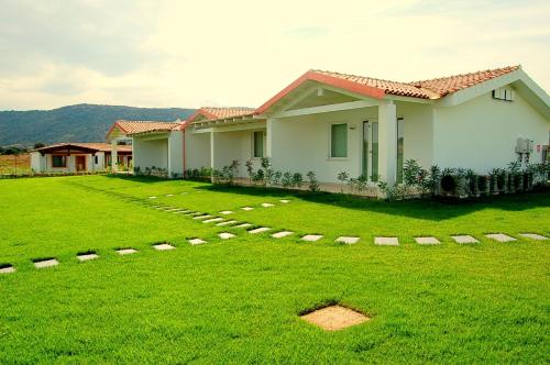 a house with a lawn in front of it at Hotel Budoni Beach in Budoni