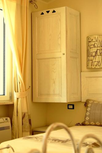 a bedroom with a white cabinet and a bed at Hotel Budoni Beach in Budoni