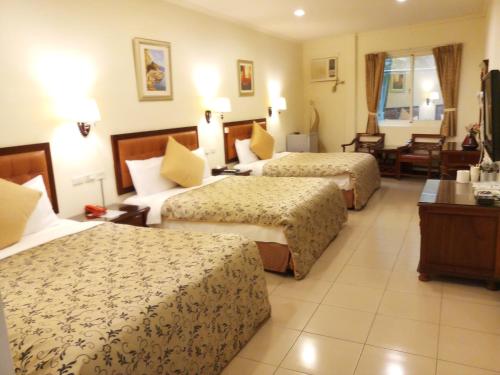 Katil atau katil-katil dalam bilik di Puti Commercial Hotel