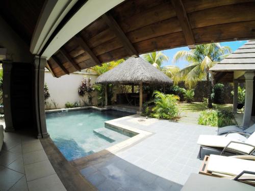 an external view of a villa with a swimming pool at Villa Dodo in Pereybere