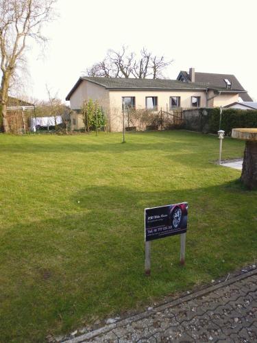 a sign in the grass in front of a house at FeWo in der Villa Gora, in Bergen auf Rügen in Bergen auf Rügen