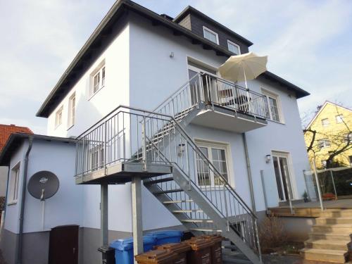 a white house with a staircase on the side of it at FeWo in der Villa Gora, in Bergen auf Rügen in Bergen auf Rügen