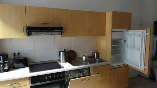 - une cuisine avec des placards en bois, un évier et une cuisinière dans l'établissement FeWo in der Villa Gora, in Bergen auf Rügen, à Bergen auf Rügen