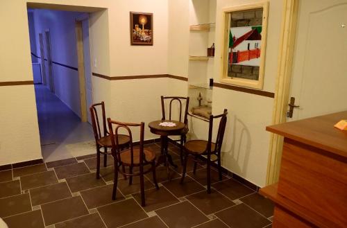 a kitchen with a table and chairs and a refrigerator at Fatornyos Tanyasi Vendégház in Békéscsaba