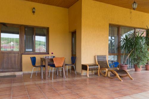 eine Terrasse mit einem Tisch und Stühlen in einem Gebäude in der Unterkunft Semeyny Guest House in Uschhorod