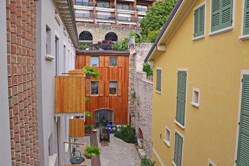 un callejón entre dos edificios con una valla de madera en Residenza Diana, en Toscolano Maderno