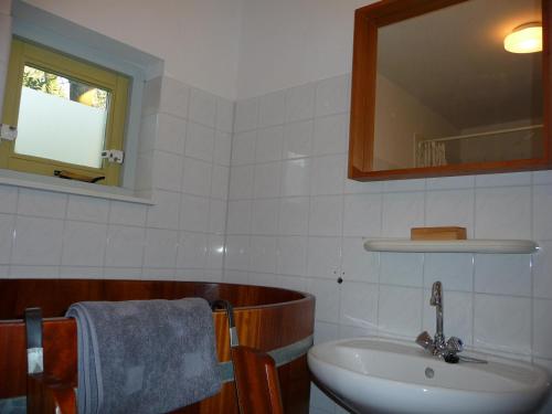 La salle de bains est pourvue d'un lavabo et d'un miroir. dans l'établissement Wellness vakantie villa, à Oudemirdum