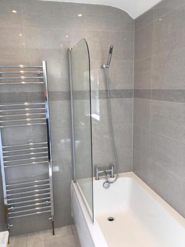 a bathroom with a shower and a bath tub at Rushden Vacation Home in Hendon