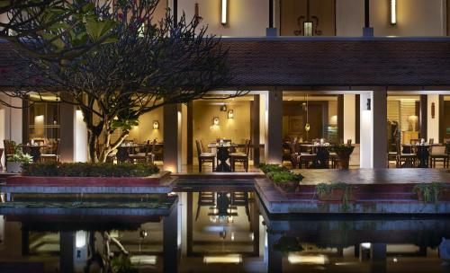 een hotel met een zwembad voor een restaurant bij Sukhothai Heritage Resort in Sawankhalok