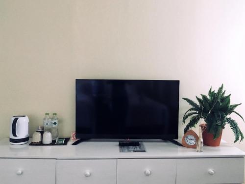 a flat screen tv sitting on top of a white dresser at Kristi House in Chiang Mai