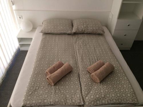 a large bed with two brown pillows on it at Apartment Luka in Portorož