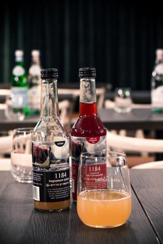 two bottles of alcohol and two glasses on a table at Hotell Bondeheimen in Oslo