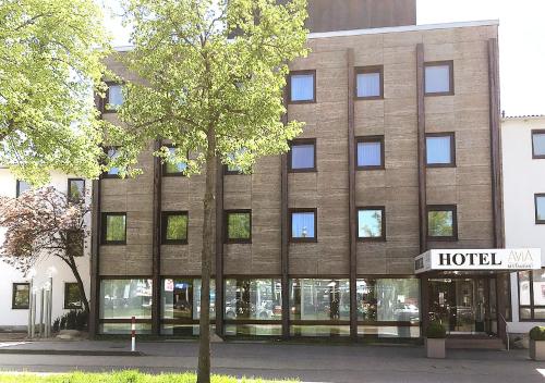 un bâtiment d'hôtel avec un arbre en face dans l'établissement AVIA Hotel, à Ratisbonne