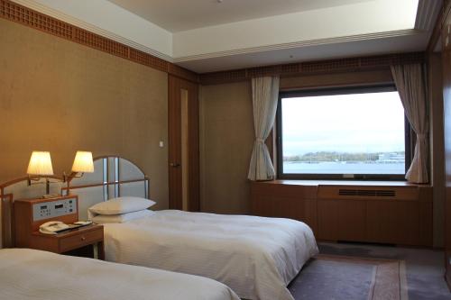 a hotel room with two beds and a window at Keihanna Plaza Hotel in Seika