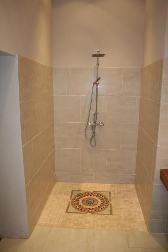 a bathroom with a shower with a cross on the wall at Le Couvent in Apt
