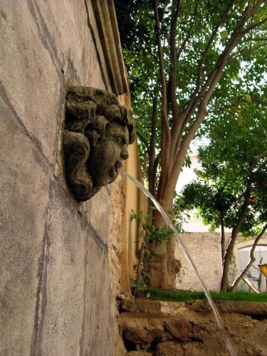 a stone wall with a gargoyle on it at Le Couvent in Apt