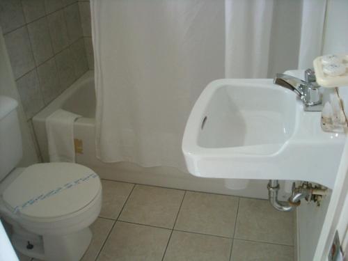 a bathroom with a toilet and a sink at Grand Motel Saint-Hubert in Longueuil