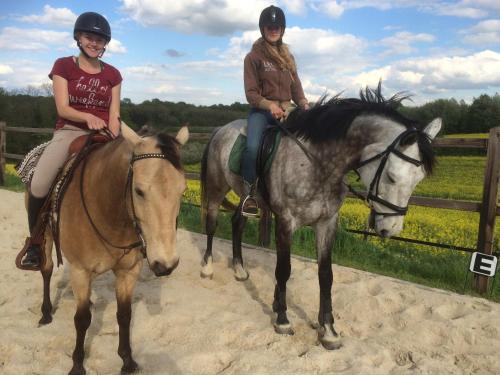 due donne a cavallo accanto a una recinzione di Voyago room relax ride a Cadier en Keer