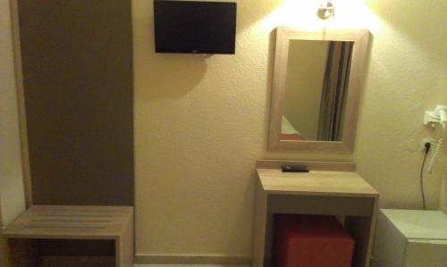 a bathroom with two tables and a mirror and a sink at Makedonia Hotel in Ouranoupoli