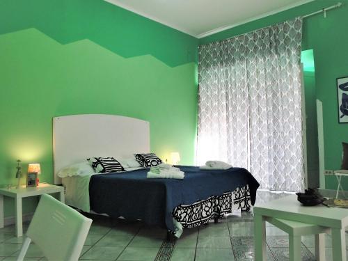 een slaapkamer met een bed en een groene muur bij Garibaldi Holiday House in Napels