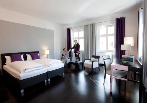 un hombre y una mujer de pie en un dormitorio en Hotel Prinz Albrecht en Neuzelle