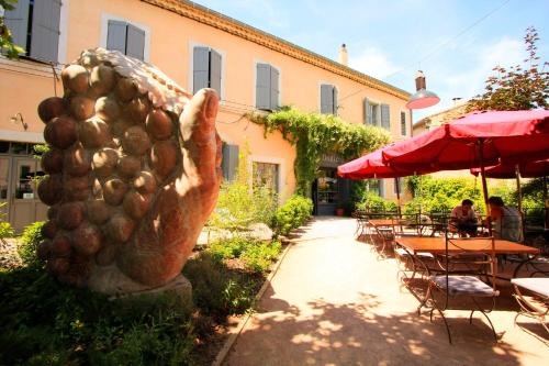 a statue of a bunch of potatoes next to a patio at Logis Hotel - Restaurant La Marbrerie in Caunes-Minervois