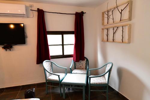a table and chairs in a room with a window at Tzlil Hateva in H̱osen